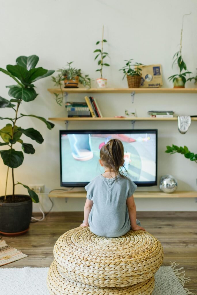 little girl is watching TV , please read our TV Buying Guide